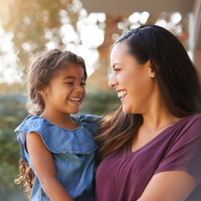 An adult holding a child, both laughing
