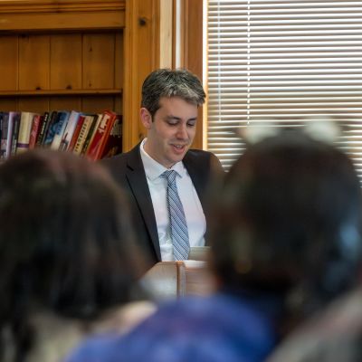 A close up of a man speaking to an audience. 