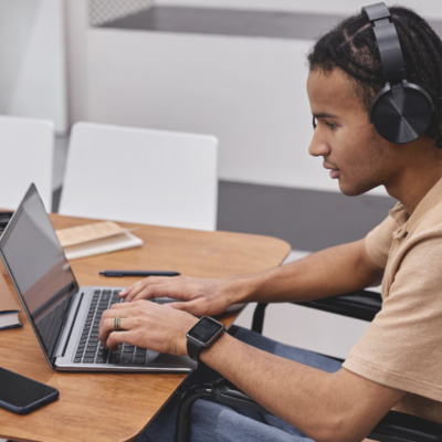black teen with headphones on laptop